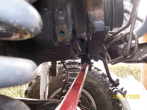 1984 Ford Bronco - Undercarriage view shows heavy-duty suspension parts and large tires on an off-road vehicle.