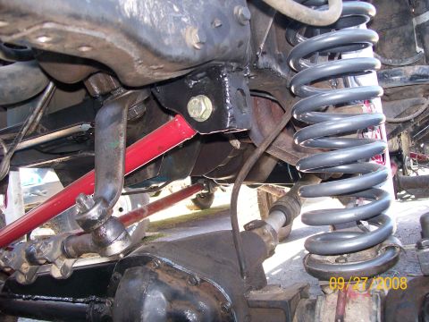 1984 Ford Bronco - Close-up of heavy-duty suspension modifications on a lifted truck, showing the front axle and steering components.