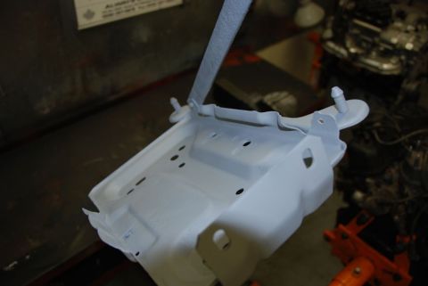 1996 Ford Bronco - A metal bracket, likely a vehicle part, is shown coated in primer.