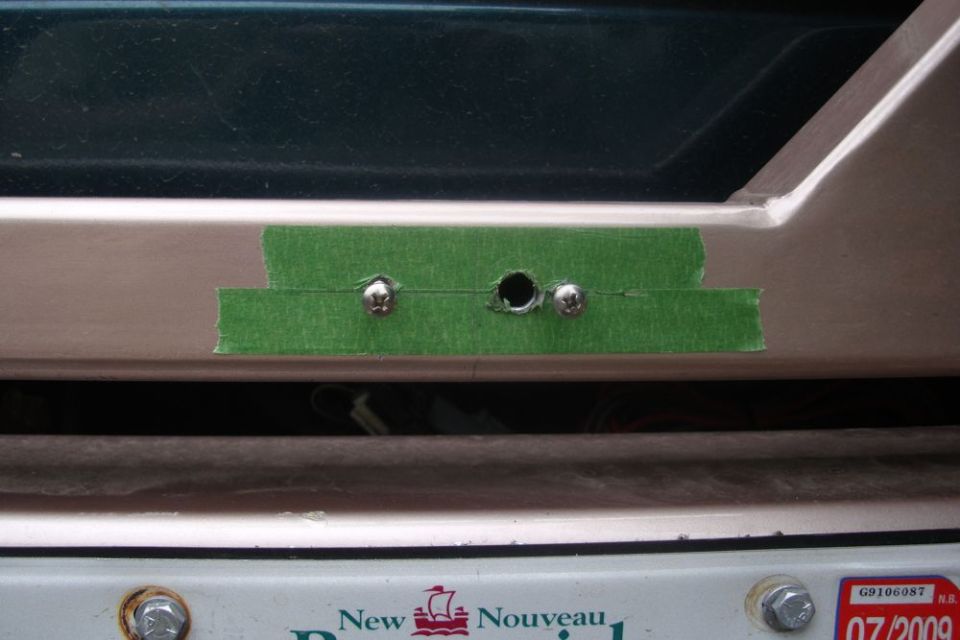 Green tape covers holes drilled for license plate light mounting