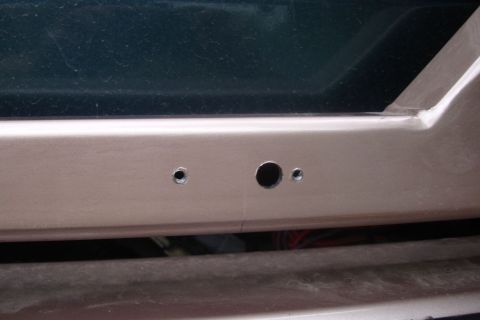 1996 Ford Bronco - This image shows the rear bumper area of a vehicle, with holes for a license plate light assembly.