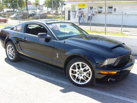 2007 Ford Mustang - Black 2007 Ford Mustang Shelby GT500 with racing stripes on the windshield.