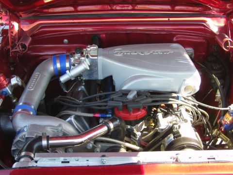 2007 Ford Mustang - Close-up of a modified engine bay, a prominent silver intake manifold labeled "Fuel Injection".