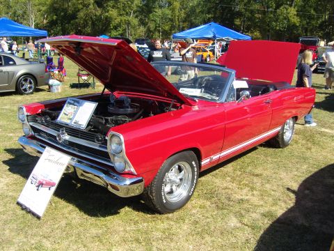 2007 Ford Mustang - A red 1966 Ford Fairlane convertible is displayed with its hood open at an outdoor car show.