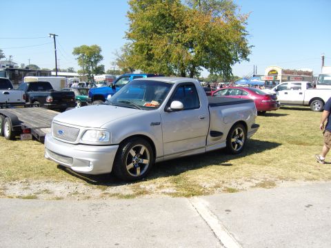 2007 Ford Mustang - Silver Ford F-150 SVT Lightning pickup truck with custom wheels and body kit.