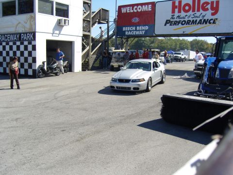 2007 Ford Mustang - A silver coupe with racing stripes on the hood drives past the grandstands at Beech Bend Raceway.