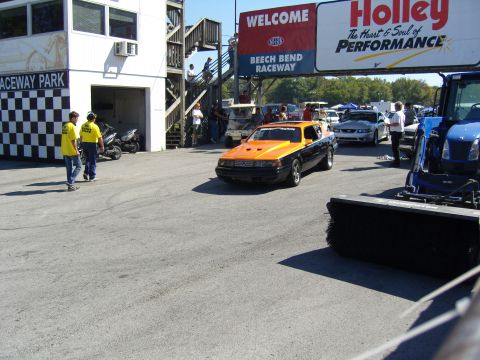 2007 Ford Mustang - A two-tone orange and black car drives onto the track at Beech Bend Raceway.