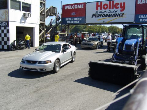 2007 Ford Mustang - A silver 2007 Ford Mustang is seen on the track at Beech Bend Raceway, with a blue tractor in the foreground.