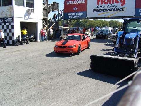 2007 Ford Mustang - Orange 2007 Ford Mustang at Beech Bend Raceway, with a blue tractor nearby.