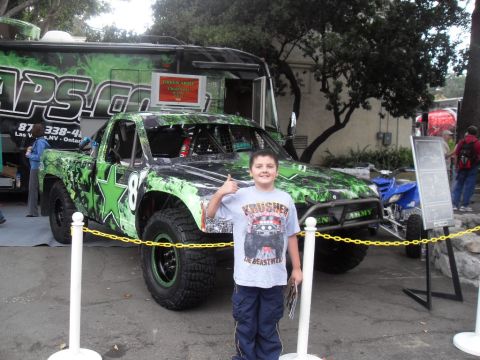 1990 Ford Bronco - Custom off-road truck with a boy and a blue ATV at an event.