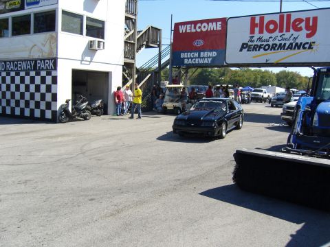 2007 Ford Mustang - A black coupe drives past the grandstands at Beech Bend Raceway under a Holley banner.