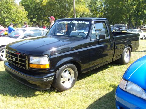 2007 Ford Mustang - A black 1995 Ford F-150 pickup truck is parked on grass, with a banner on the windshield reading "High Performance Transmissions".