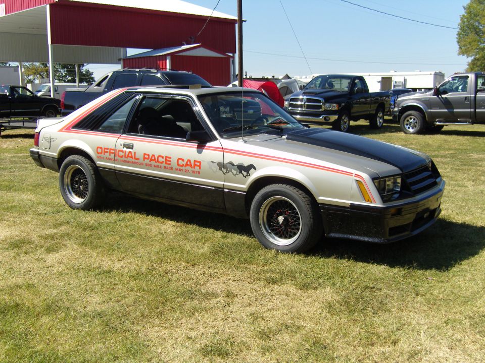 Silver 1979 Ford Mustang Pace Car with black hood and red stripes, parked on grass