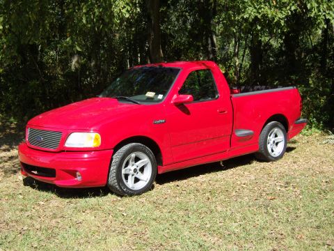 2007 Ford Mustang - This red Ford F-150 SVT Lightning pickup truck is shown from a 3/4 front angle.