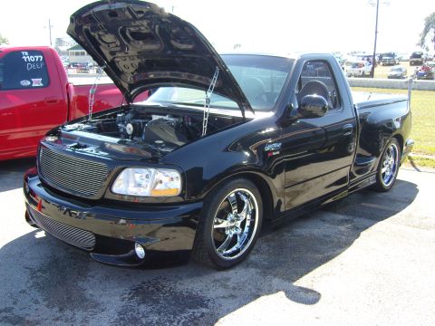 2007 Ford Mustang - Modified black Ford F-150 Lightning pickup truck with custom grille and wheels.