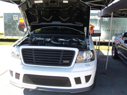 2007 Ford Mustang - A white Saleen pickup truck is parked with its hood open, revealing the engine bay.