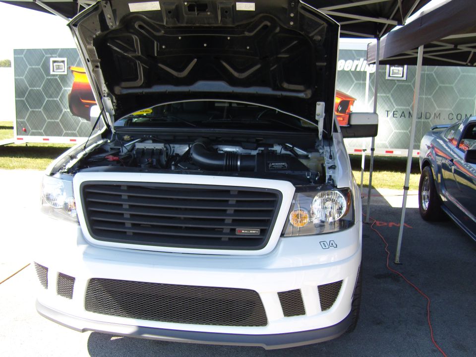 White Saleen pickup truck front view, hood open, showing engine. "04" decal on bumper