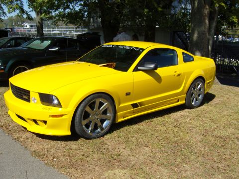 2007 Ford Mustang - A bright yellow Saleen Mustang is parked on a grassy area, with another vehicle in the background.