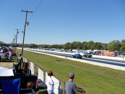 2007 Ford Mustang - Spectators watch cars compete on a drag strip under a clear blue sky.