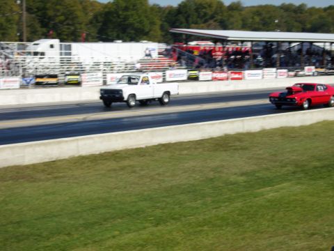 2007 Ford Mustang - Photograph of two cars racing at a drag strip, an action vehicle photo not a technical document.
