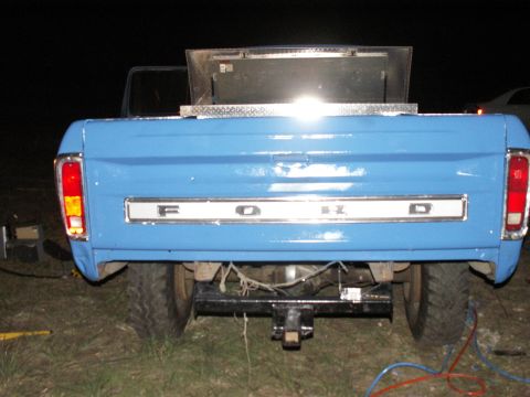 1977 Ford F-250 - Blue 1977 Ford F-250 pickup truck, seen from the rear, the F-O-R-D tailgate lettering and a metal toolbox.
