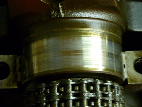 1988 Ford Bronco - This image shows a close-up view of a worn engine crankshaft bearing and a timing chain.