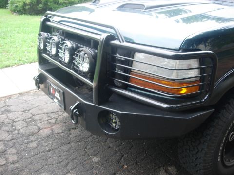 1993 Ford Bronco - Front view of a dark green 1992 Ford Bronco, equipped with auxiliary lights and a heavy-duty bumper.