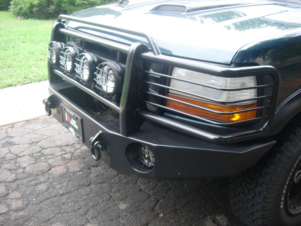 Dark green 1992 Ford Bronco front bumper with KC lights and a brush guard