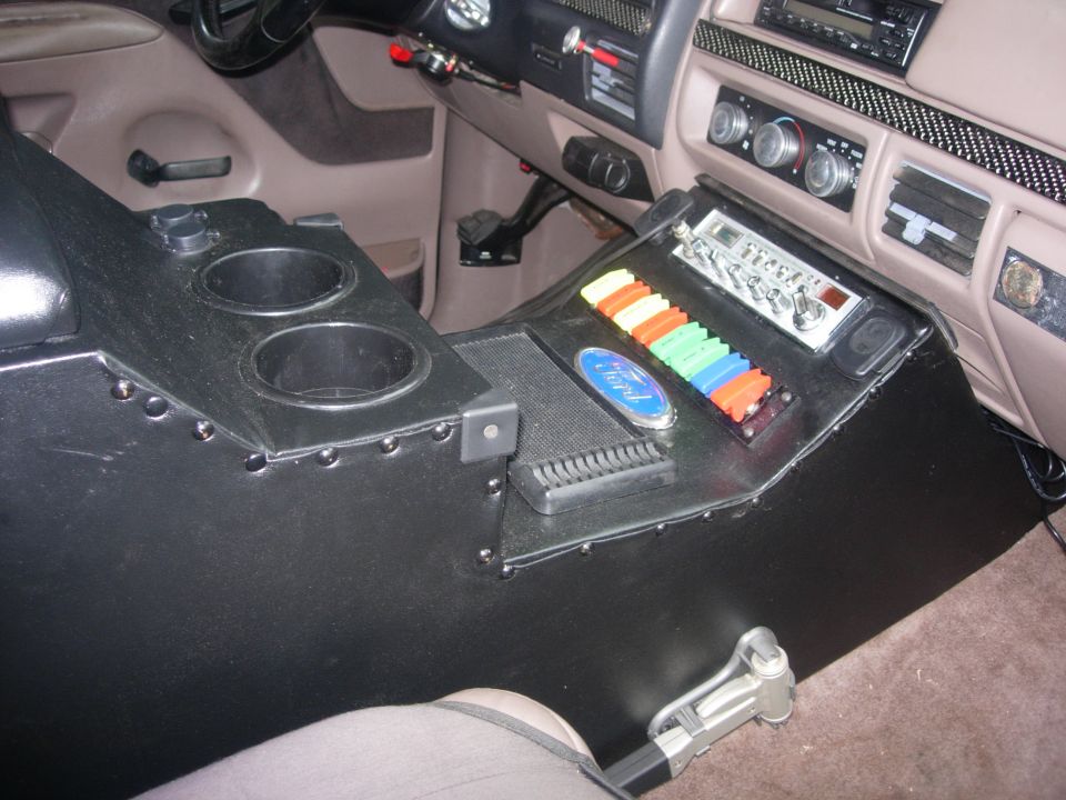 Interior of a Ford Bronco with custom center console, CB radio, and toggle switches.