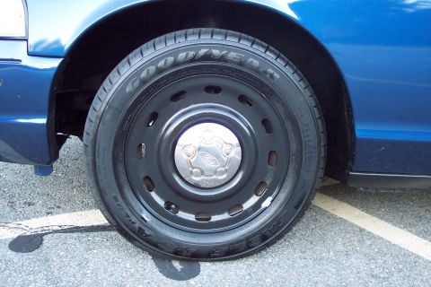 2001 Ford Crown Victoria - Close-up of a blue 2001 Ford Crown Victoria's wheel, a Goodyear Eagle tire and a Ford-branded center cap.