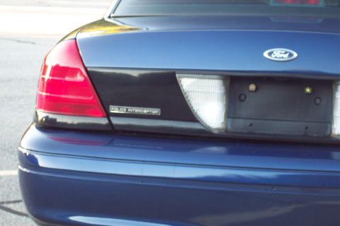 2001 Ford Crown Victoria - Blue 2001 Ford Crown Victoria Police Interceptor rear view with "POLICE INTERCEPTOR" badging visible.
