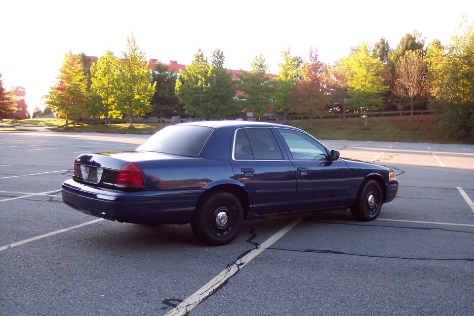 2001 Ford Crown Victoria sedan, dark blue, parked in a lot, rear 3/4 view