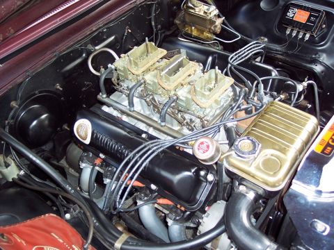 1963 Ford Galaxie - Close-up view of a V8 engine a triple carburetor setup and custom valve covers.