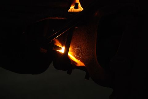 1996 Ford Bronco - A close-up shot shows a welding torch in action, creating sparks and intense heat on a metal component.