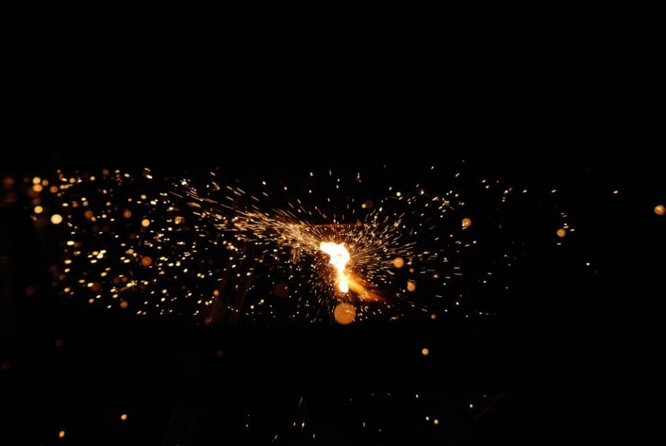 Sparkler shooting off bright orange sparks against a black background