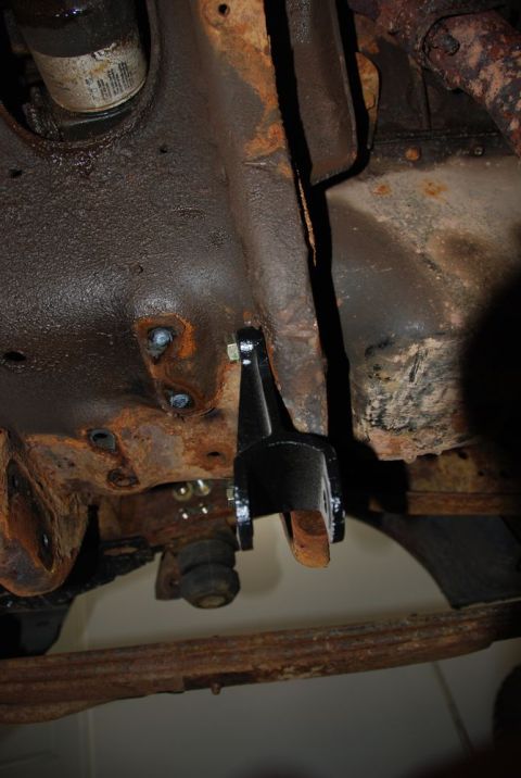 1996 Ford Bronco - Undercarriage view of a heavily rusted vehicle frame with a newly installed black bracket.