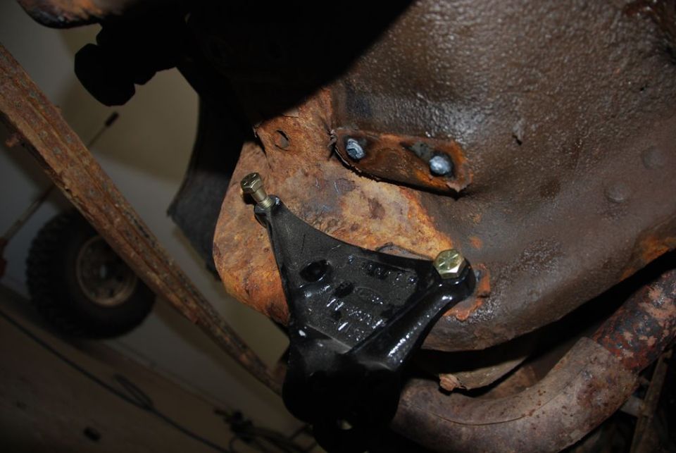Black bracket on rusty undercarriage with visible text