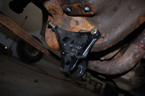 1996 Ford Bronco - Close-up of a vehicle's suspension component attached to a heavily rusted frame.