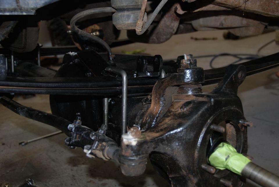 Undercarriage suspension components with black paint and green tape on axle