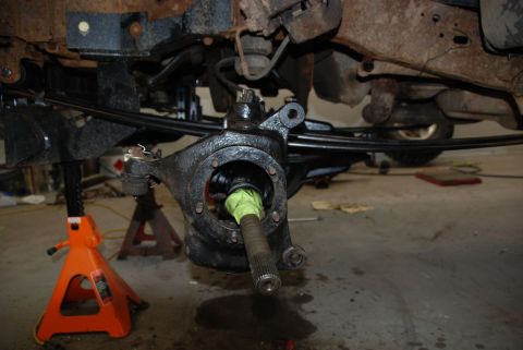 1996 Ford Bronco - The vehicle is on jack stands, showing the front axle hub assembly removed for maintenance.