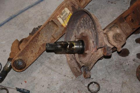 1996 Ford Bronco - Close-up of a rusty front axle assembly, showing a splined shaft and brake rotor, likely from an older truck or off-road vehicle.
