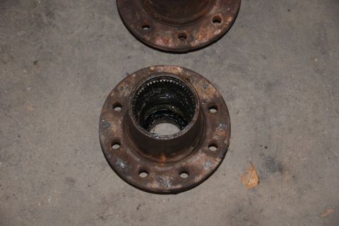 1996 Ford Bronco - Close-up of two rusty wheel hubs, showing the splined interior and bolt mounting pattern.