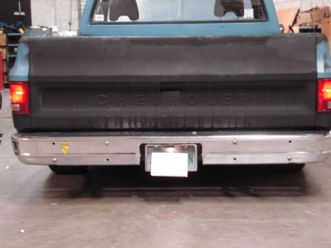 1979 Chevrolet C/K Pickup - The rear of a Chevrolet pickup truck is shown, a chrome bumper and the embossed 'CHEVROLET' lettering on the tailgate.