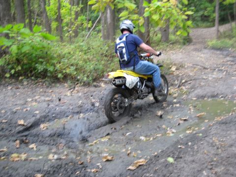 1993 Suzuki RMX250 - Rider navigates a muddy off-road trail on a yellow 1993 Suzuki RMX250.