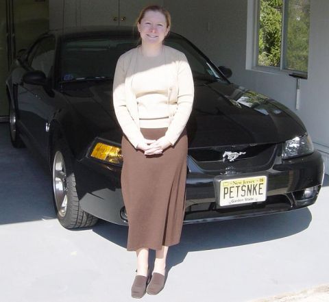 2001 Ford Mustang - A woman stands in front of a black 2001 Ford Mustang in a garage.