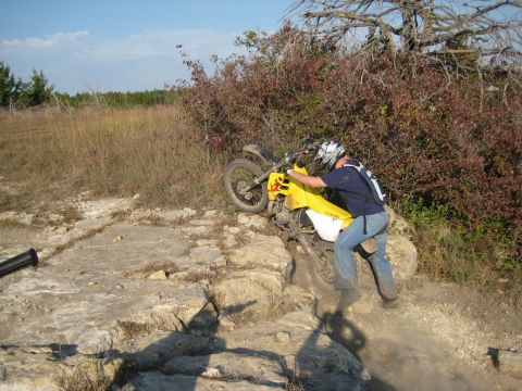 1993 Suzuki RMX250 - A rider navigates a challenging rocky terrain on a dirt bike.