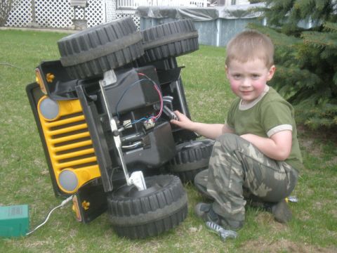 1963 Ford Galaxie - A young boy inspects the inner workings of a toy jeep that has been flipped over.