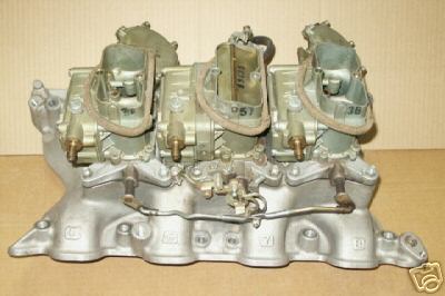 1972 Ford Ranchero - A silver tri-power carburetor manifold with three carburetors is shown against a neutral background.