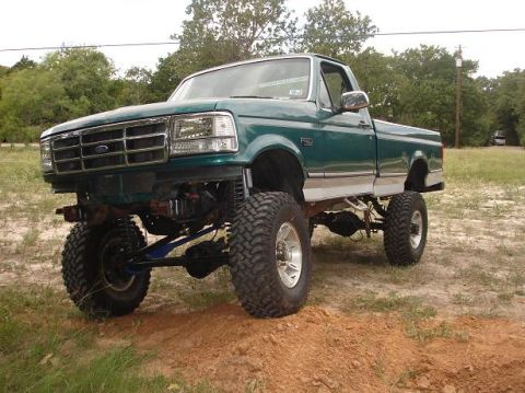 1996 Ford F-150 - This lifted 1996 Ford F-150 pickup truck is shown from a three-quarter front view, highlighting its modifications.
