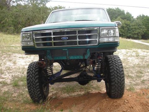 1996 Ford F-150 - This Ford truck features a prominent grille and headlights, with its suspension and large tires clearly visible.